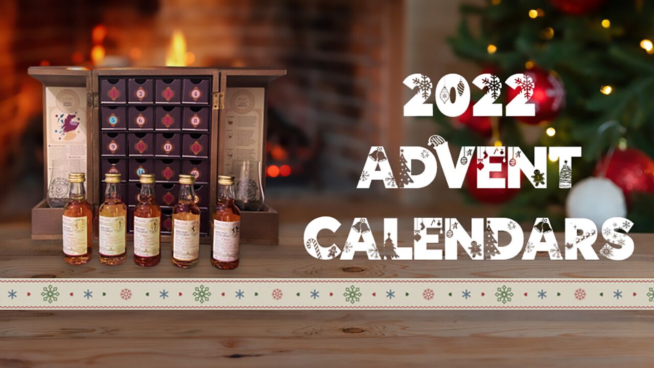 Edited photograph of an advent calendar on a wooden desk with some windows open, showcasing some of the miniatures included in it. To the right, a christmas decorated text reading: 2022 Advent Calendars
